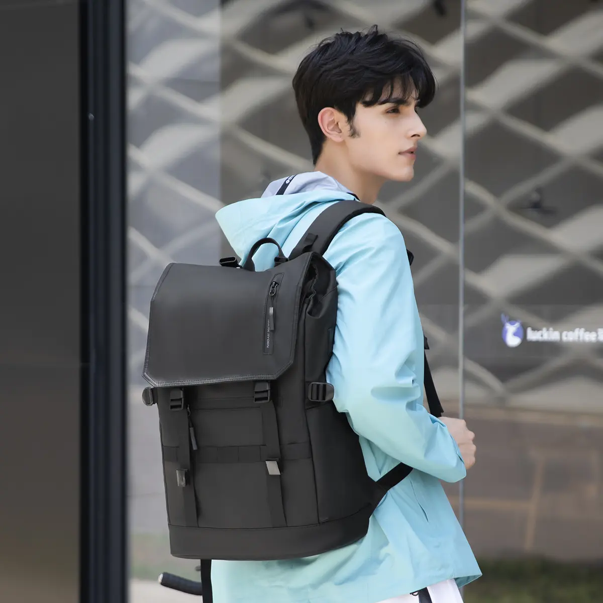 A young man carrying Mark Ryden Laptop Backpack Black MR5748SJ 