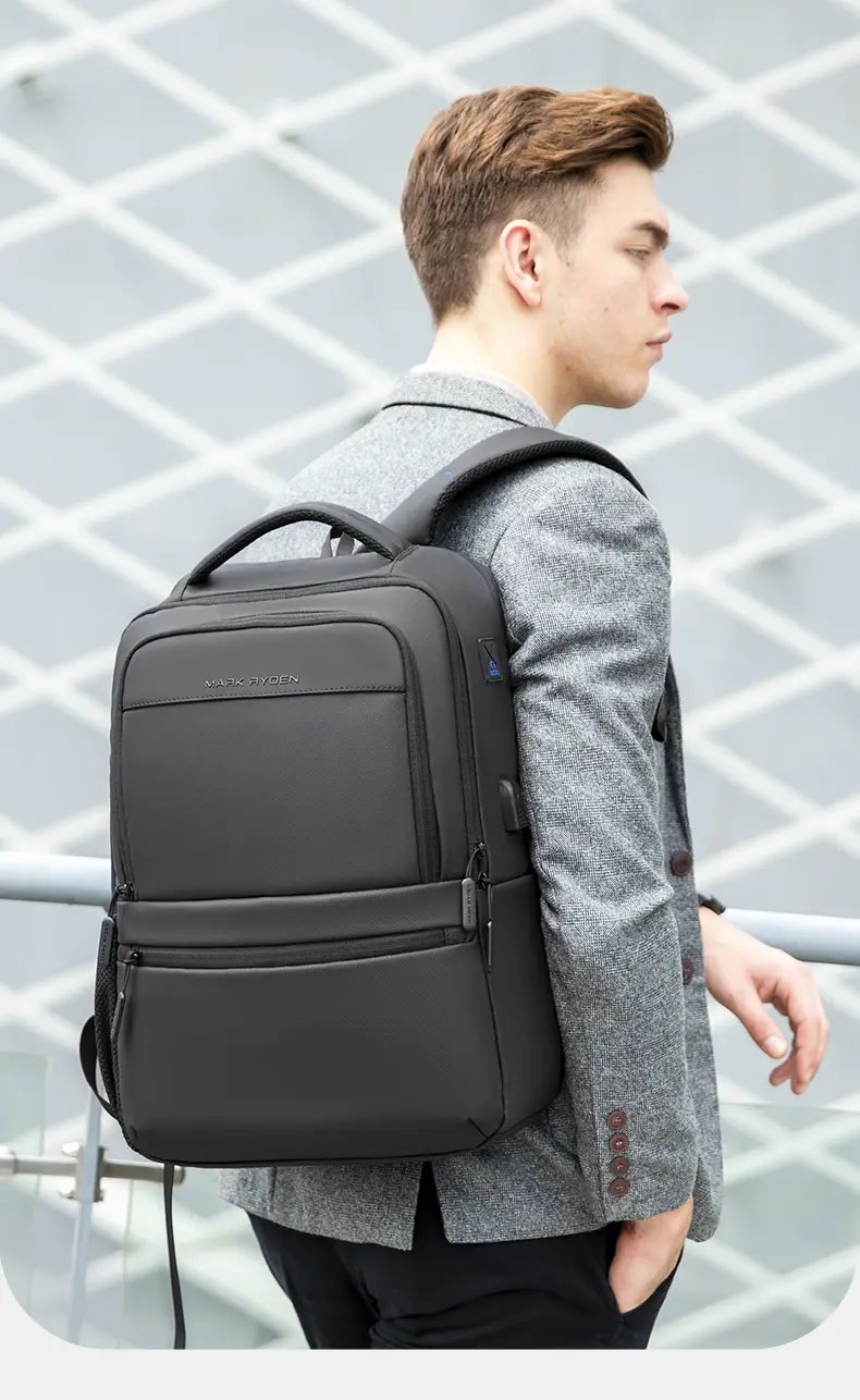 A young man in a gray blazer carries Mark Ryden Laptop Backpack Black MR9103SJ 